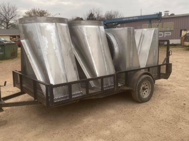 a trailer with a bunch of stainless steel pipes on it