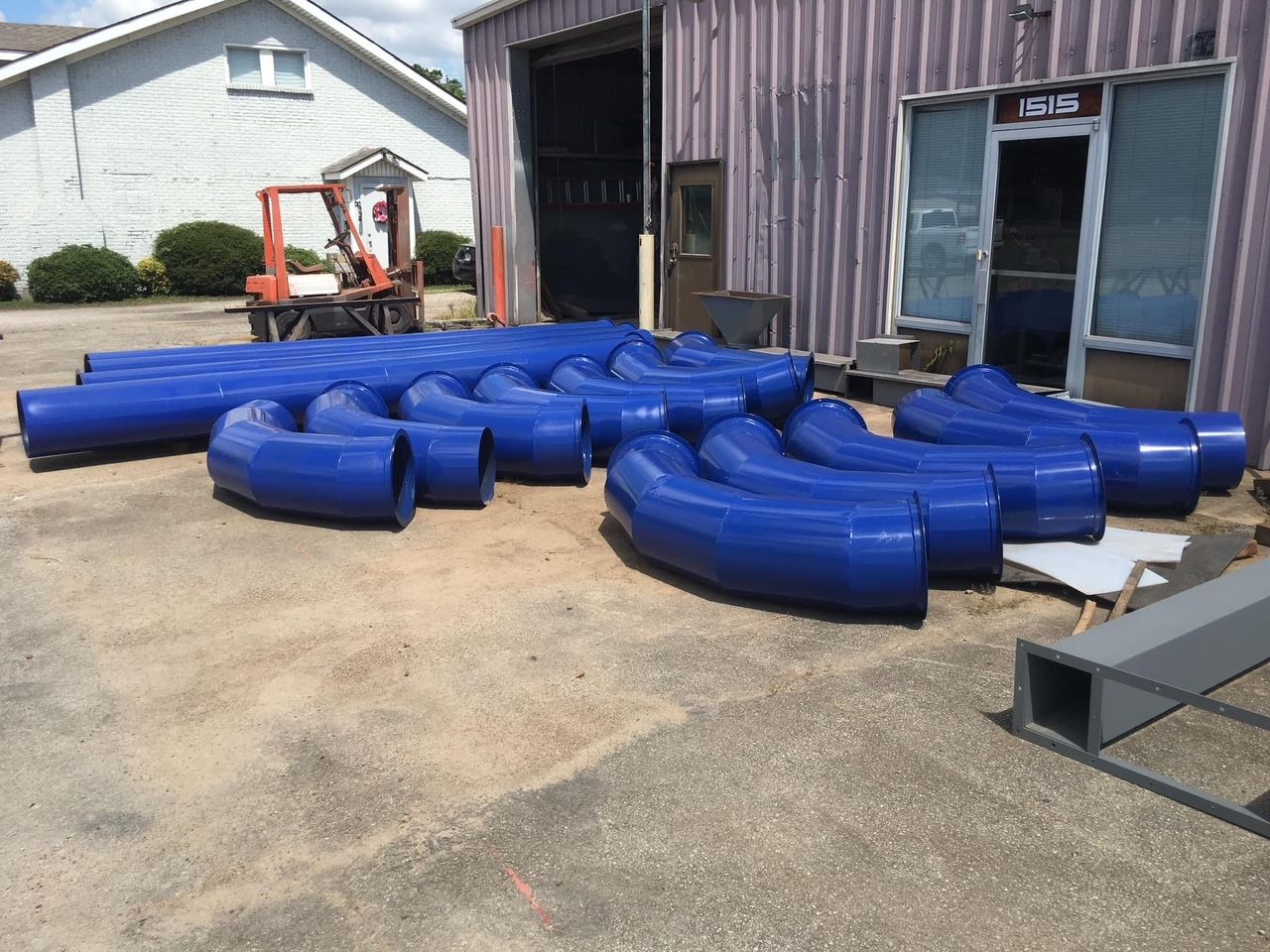a bunch of blue pipes are sitting outside of a building