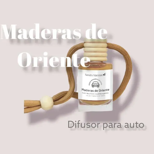 Difusor para auto Maderas de Oriente, frasco pequeño con cordón beige sobre fondo rosa claro.