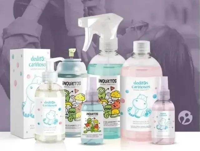 Varios productos de cuidado para bebés con etiquetas de dibujos animados sobre un fondo morado, incluidos biberones