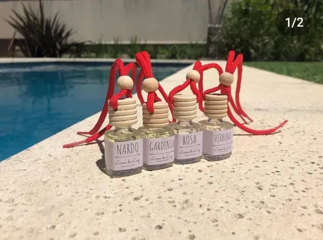 Fila de pequeñas figuras rojas y color crema en el borde de una piscina, junto al agua azul