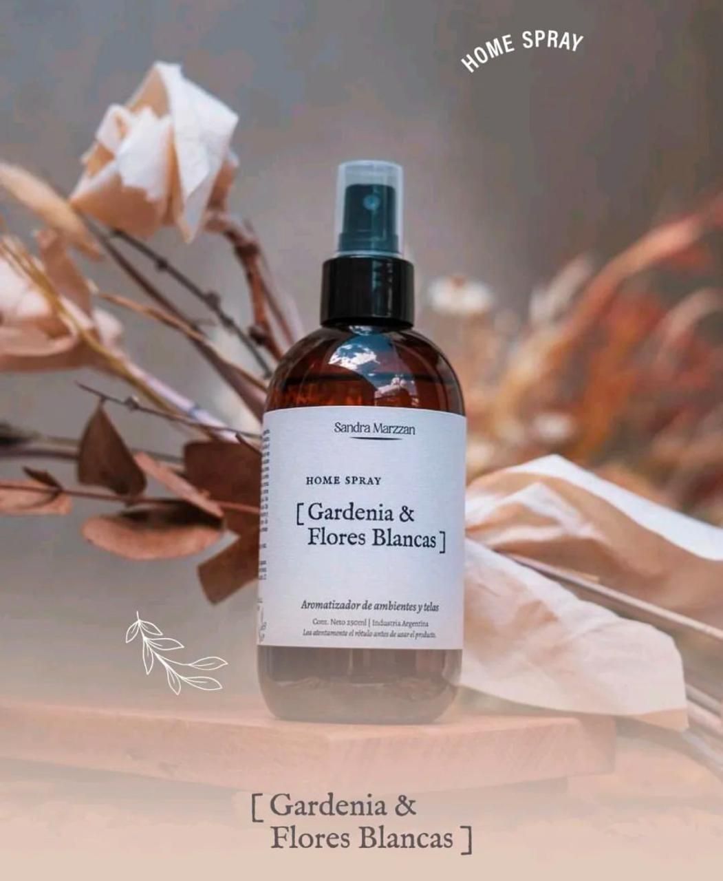 Frasco ámbar de ambientador en spray Gardenia & Honeysuckle con flores secas marrones sobre un fondo beige suave