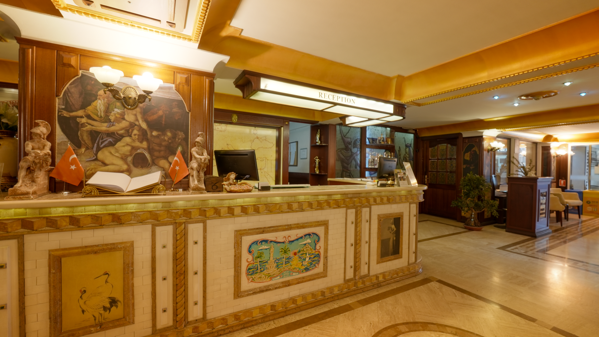 İzmir Park Hotel lobby features an ornate reception desk with tiled inlays and a mural, warm lighting, and marble floors.