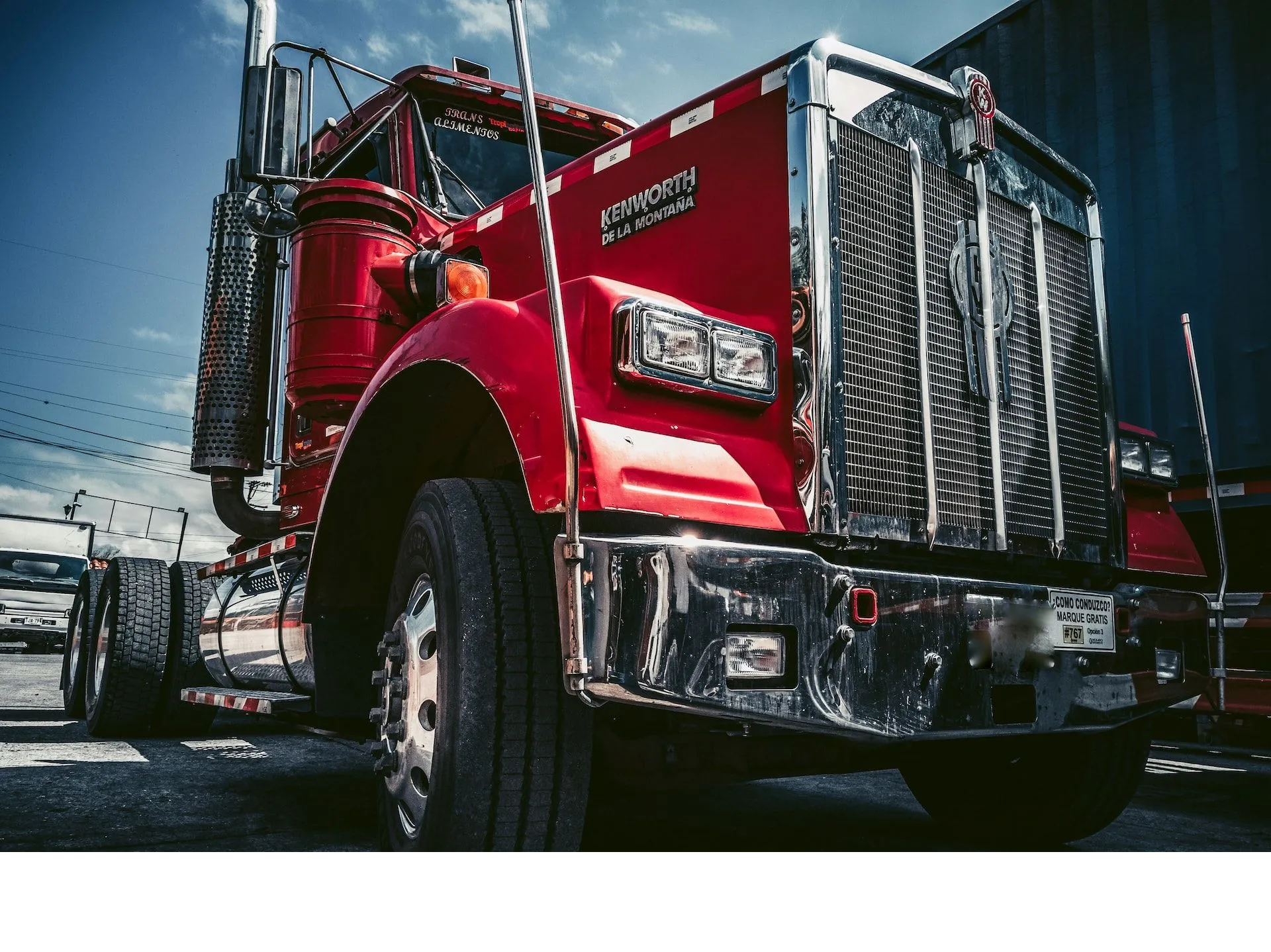 A red semi truck is parked on the side of the road.