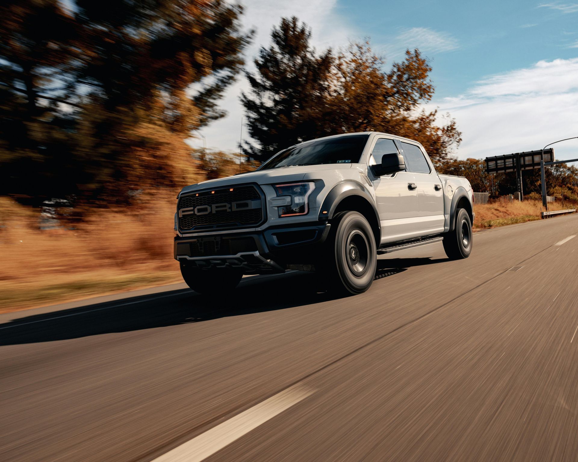 A white ford truck on the road.