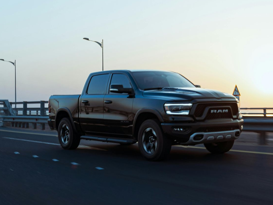 A black dodge ram on a road.