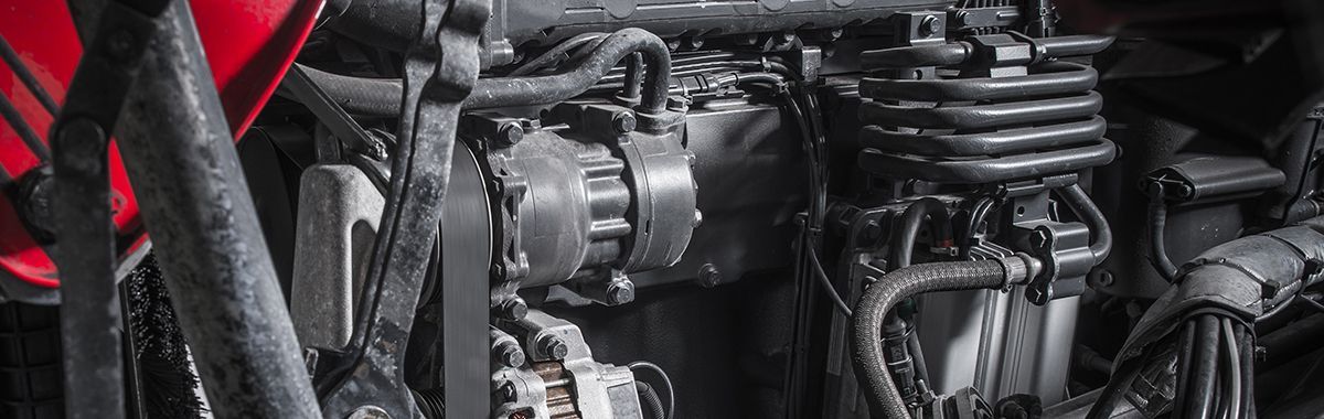 A close up of a black and red engine with a fan.