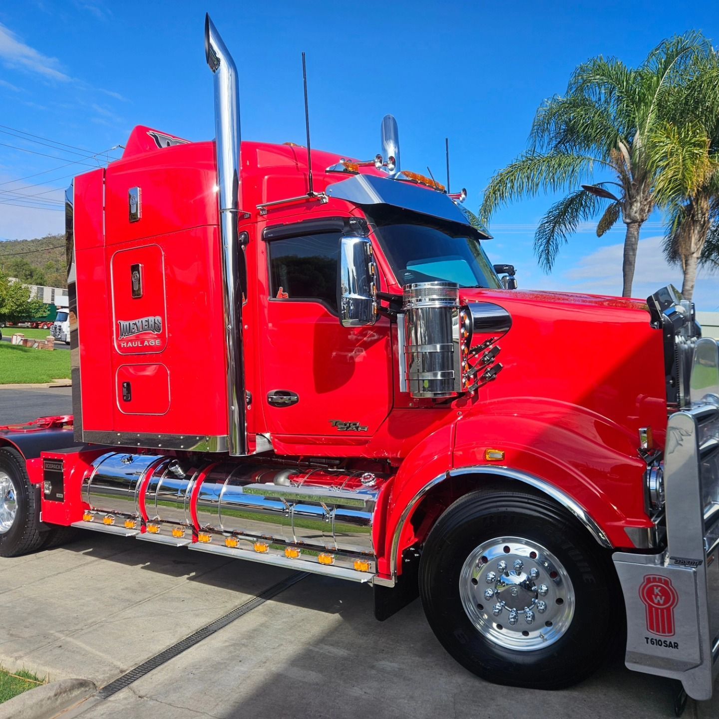 Bright red semi-truck parked on a sunny street with palm trees and blue sky — On Point Detailing Wagga in East Wagga Wagga, NSW