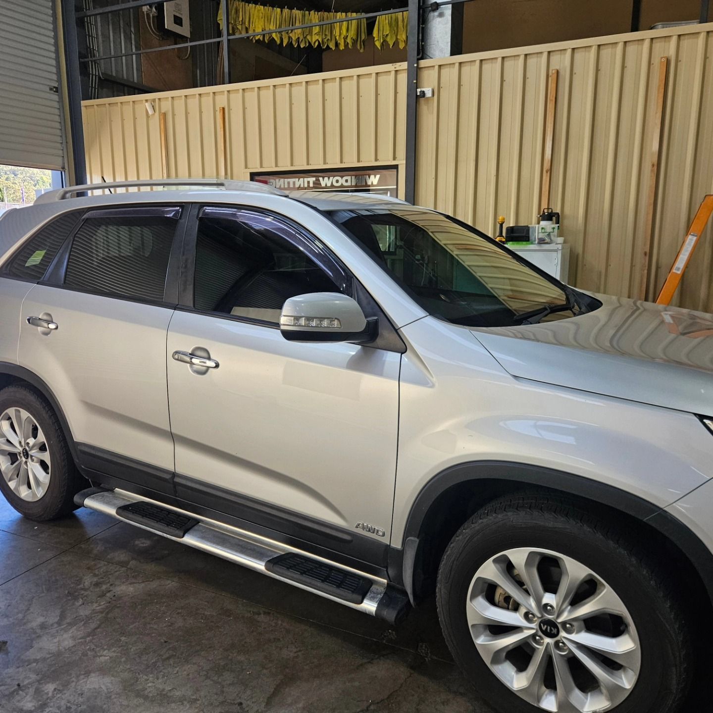 Silver SUV parked in a garage, side view with chrome running boards and tinted windows — On Point Detailing Wagga in East Wagga Wagga, NSW