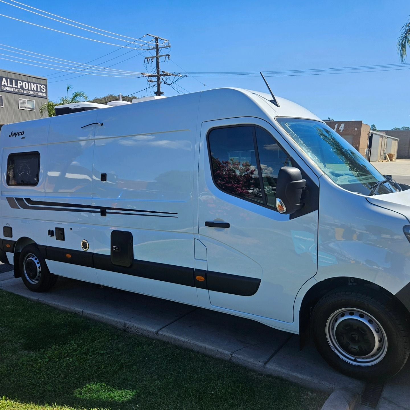 White camper van parked on a sunny street beside a grassy curb and utility poles. — On Point Detailing Wagga in East Wagga Wagga, NSW