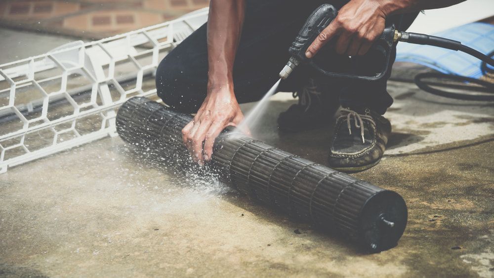 Person Cleaning an Air Conditioner Filter — Hinterland Air Conditioning Sunshine Coast in Palmwoods, QLD