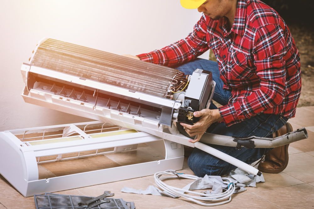 Technician in Works on Air Conditioner Unit, Outdoors — Hinterland Air Conditioning Sunshine Coast in Maleny, QLD
