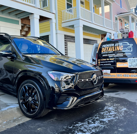 Black SUV outside a building, with a detailing van parked behind it