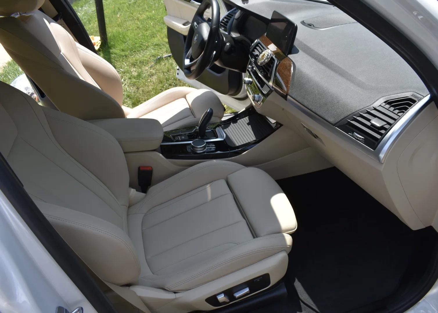 Tan leather car interior with dashboard, steering wheel, and center console.