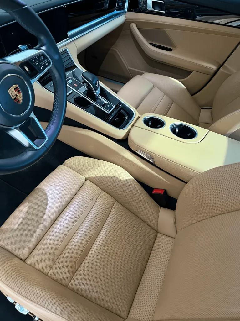 Tan Porsche interior with tan leather seats, center console, and steering wheel