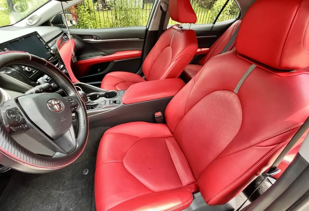 Red leather car interior with steering wheel and front seats visible