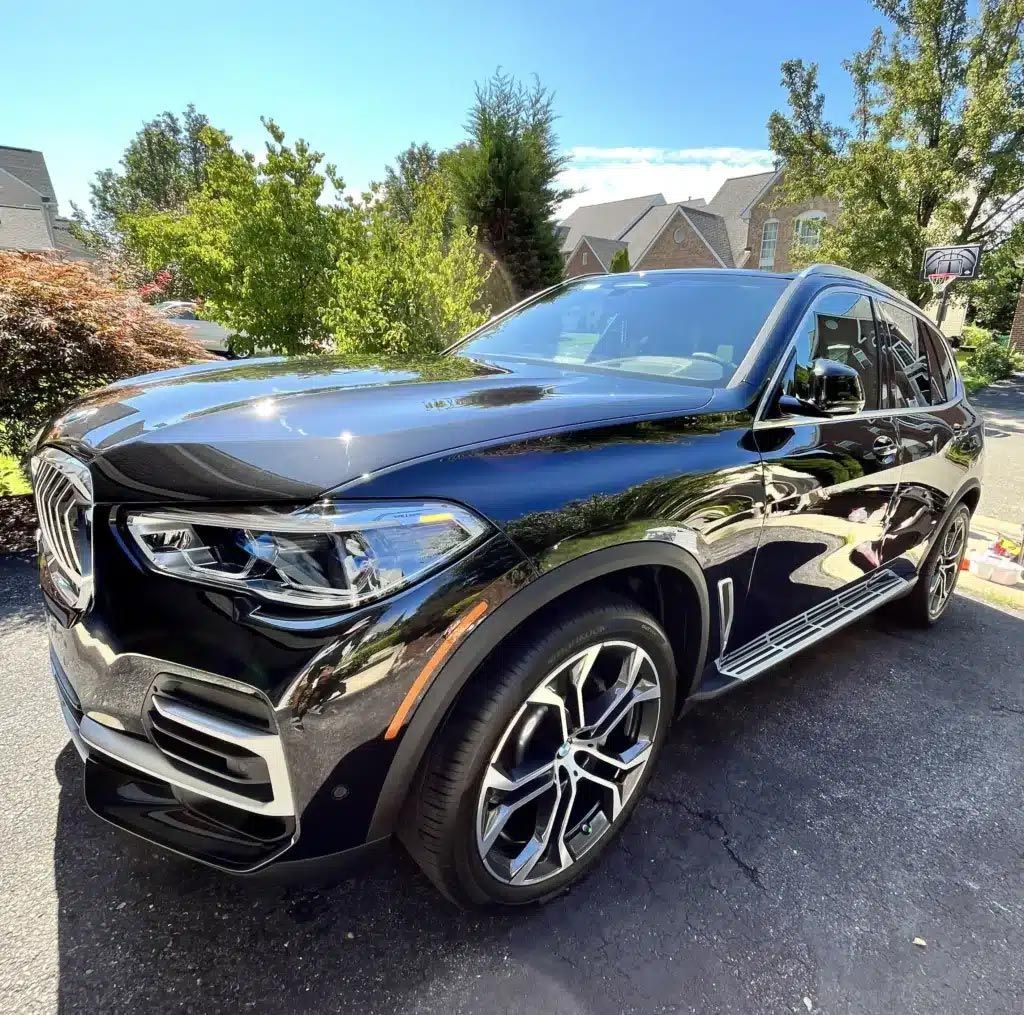 Black Mercedes SUV parked in a driveway, front three-quarter view