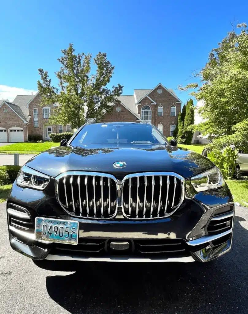 Black BMW SUV parked in a suburban driveway on a sunny day