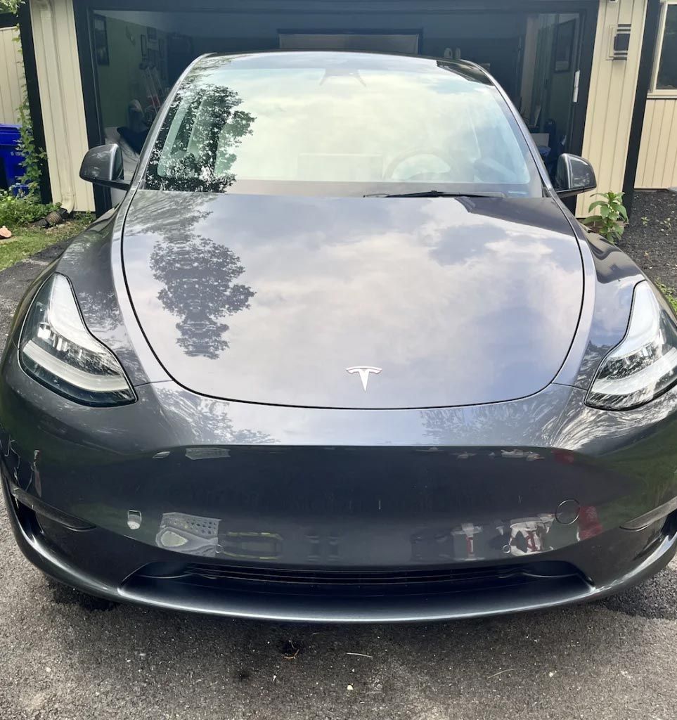 Front view of a gray Tesla parked in a driveway