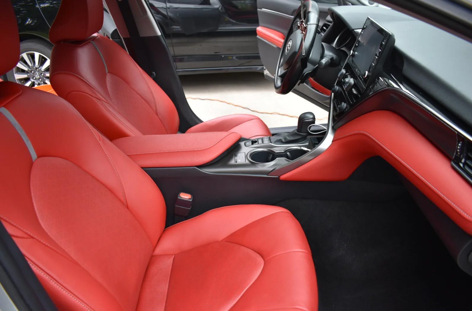 Red leather car interior with sporty front seats and a modern dashboard