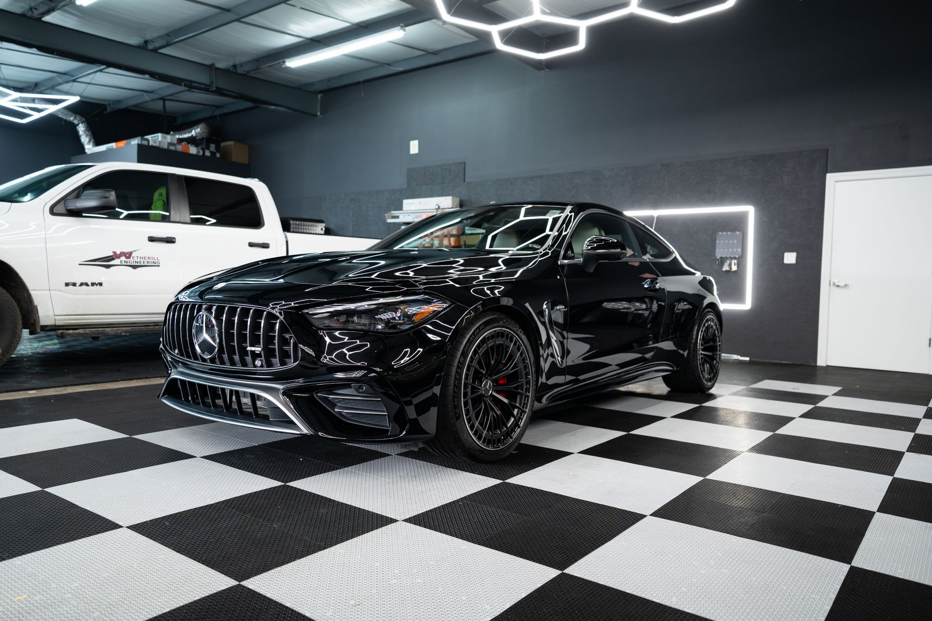Black Mercedes SUV in a showroom with checkered floor and bright ceiling lights