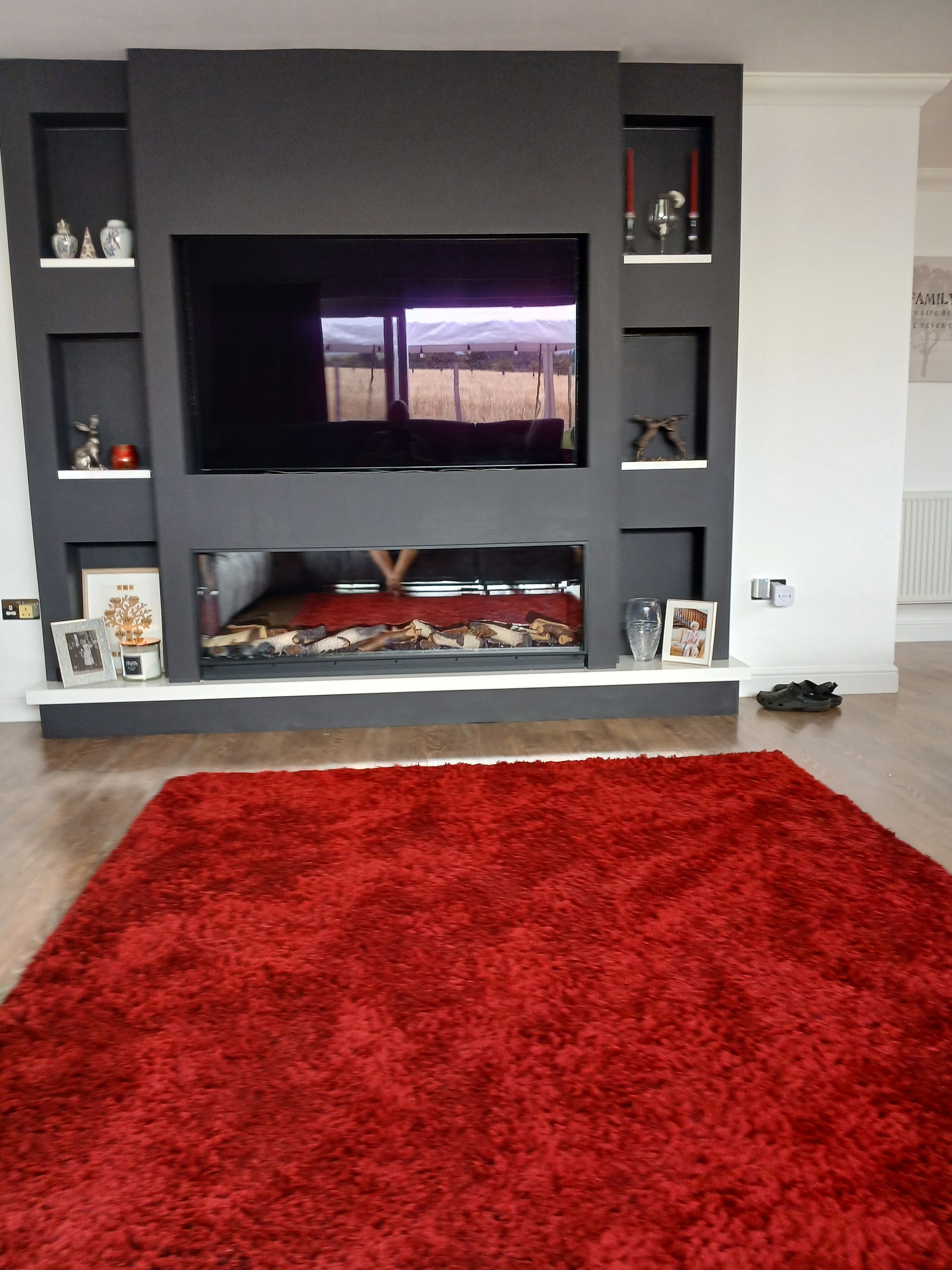 Modern built-in fireplace with shelving and TV unit in a stylish living room
