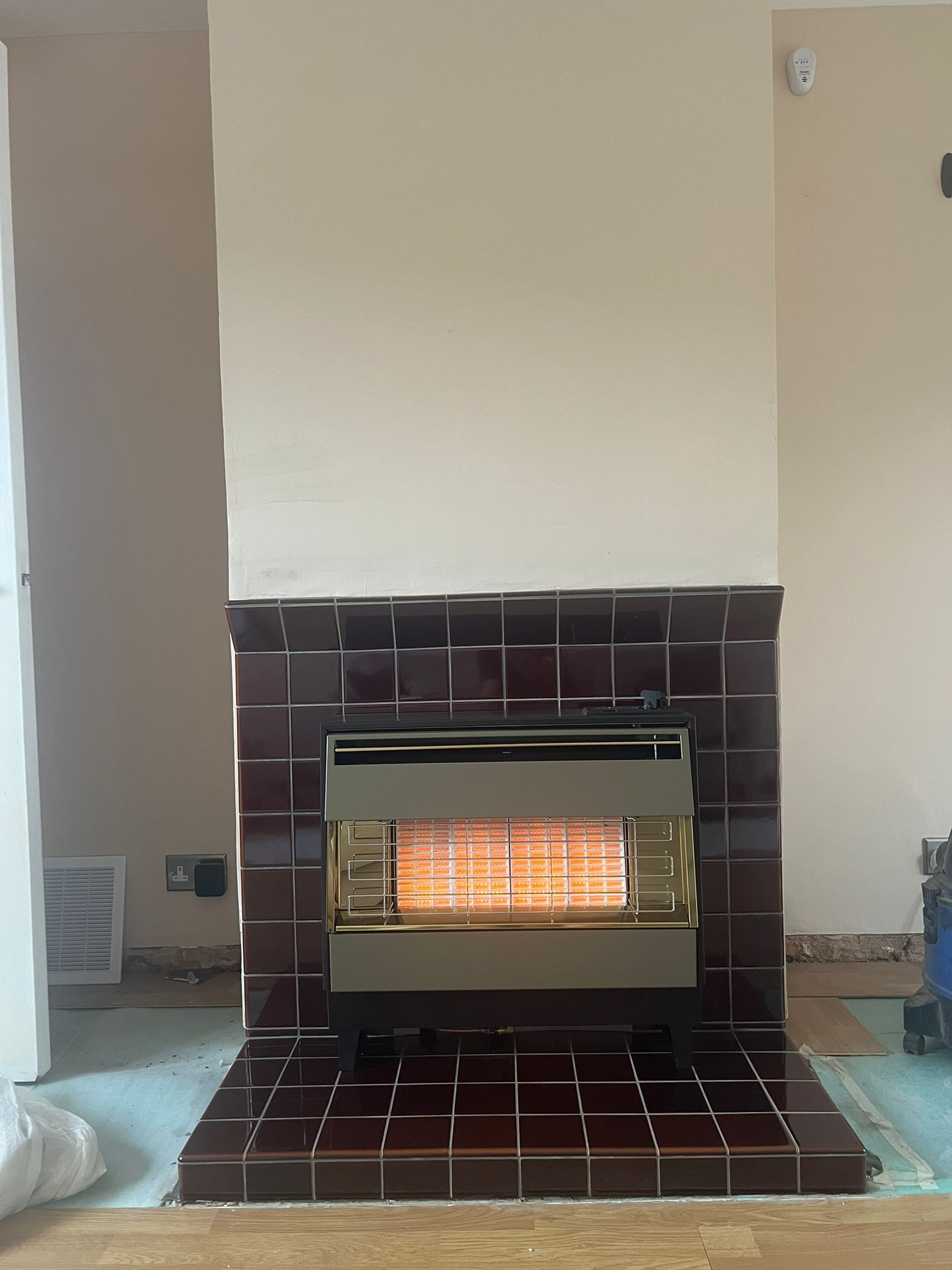 a gas heater installed within a tiled fireplace