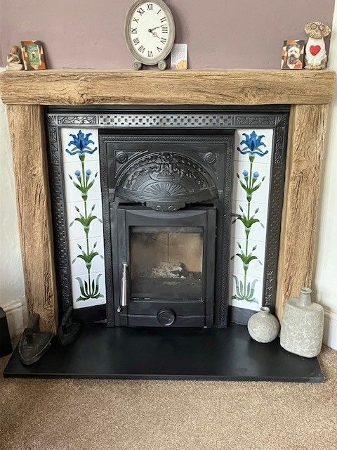 Traditional fireplace with wood mantel and decorative tiled surround.