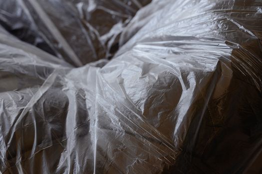 Envoltura de plástico transparente colocada sobre un objeto invisible, creando pliegues arrugados y reflejos.