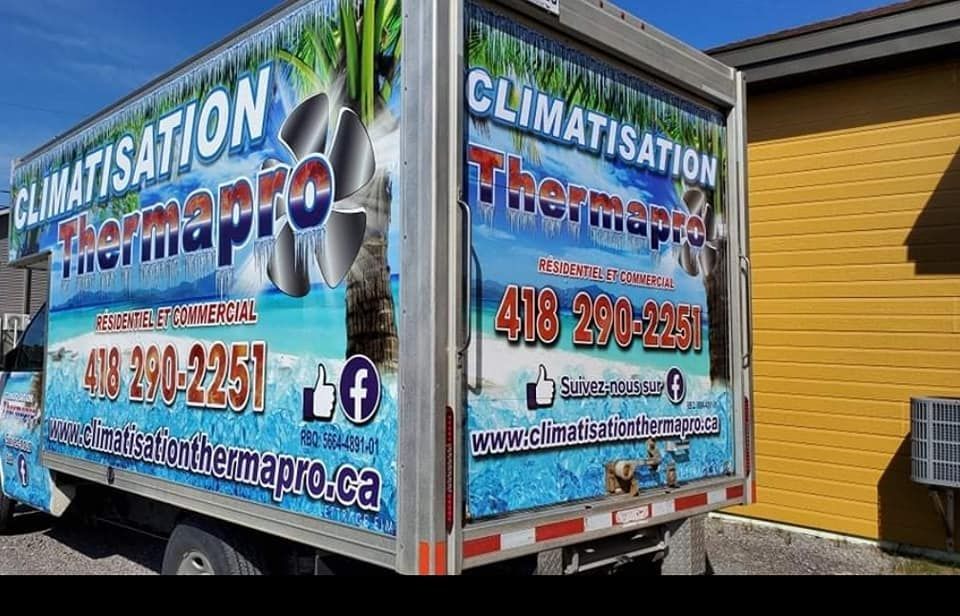 Un camion thermopro est stationné devant un immeuble.