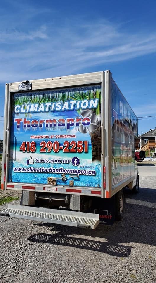 Un camion réfrigéré est garé sur le bord de la route.