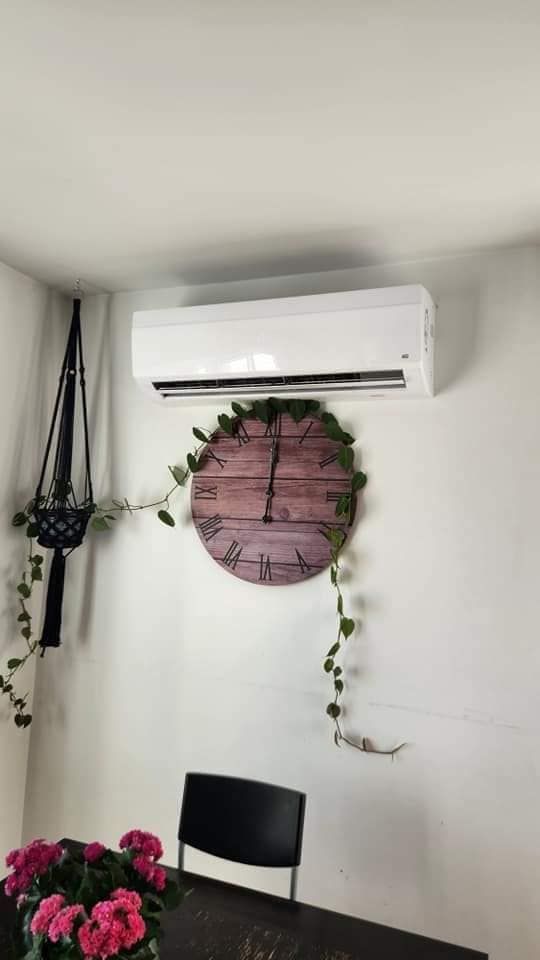 Il y a une horloge sur le mur au dessus du climatiseur.