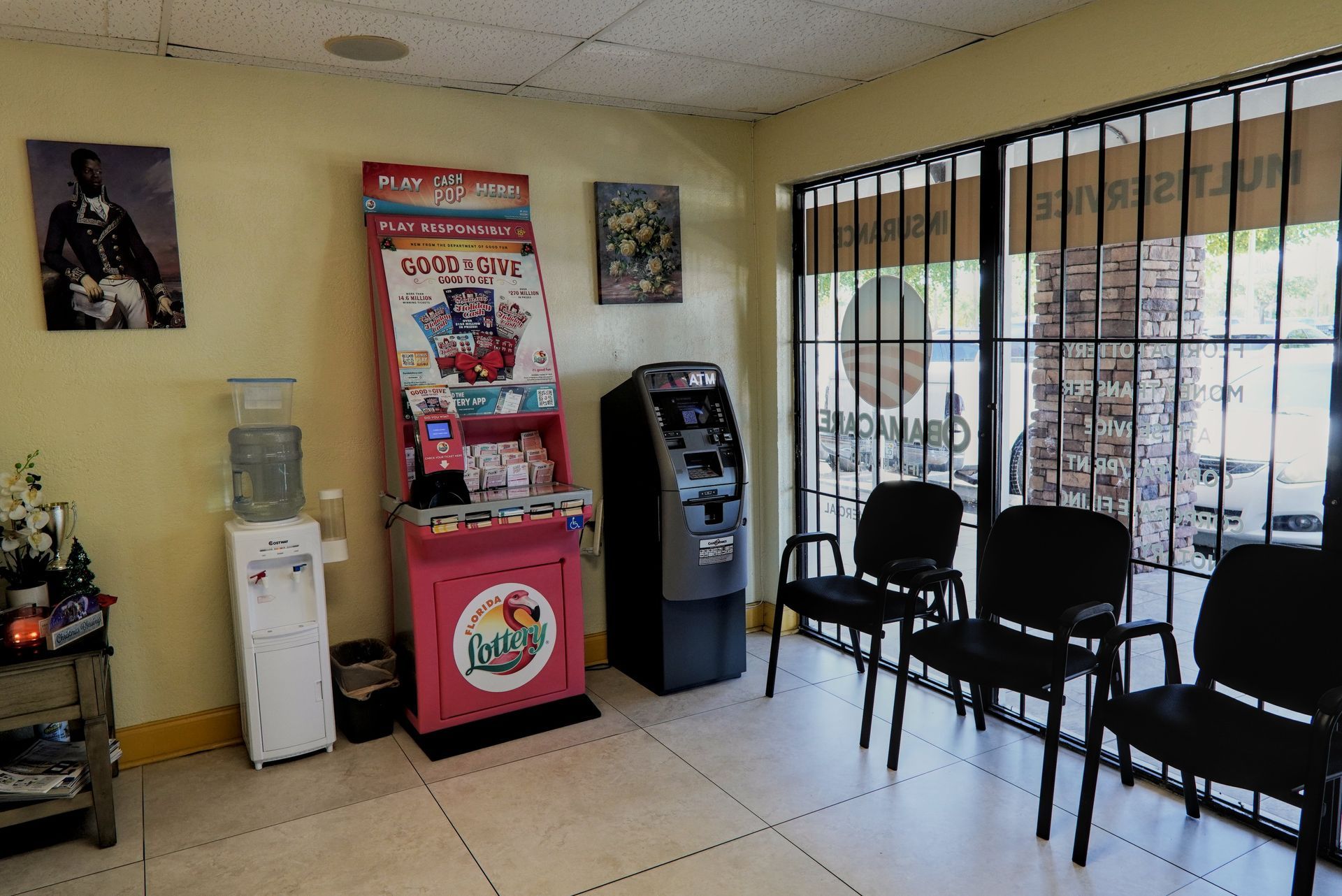 Waiting room with chairs, vending machines, water dispenser, and art. Large windows to outside.