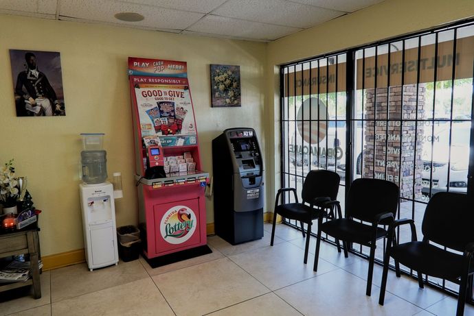 Waiting room with chairs, a water cooler, vending machine, and ATM. A painting hangs on the wall.