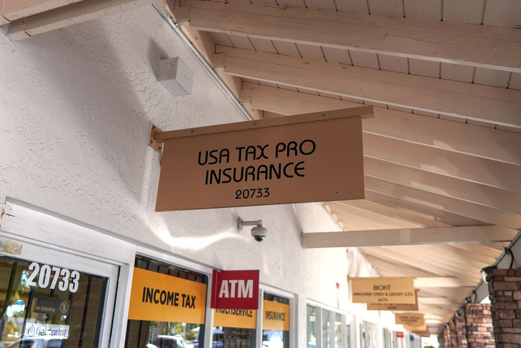 Sign for USA Tax Pro Insurance at 20733, with other storefronts visible.