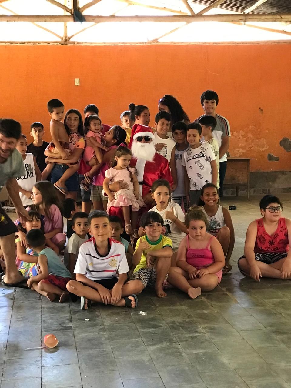 Um grupo de crianças posa para uma foto com o Papai Noel.
