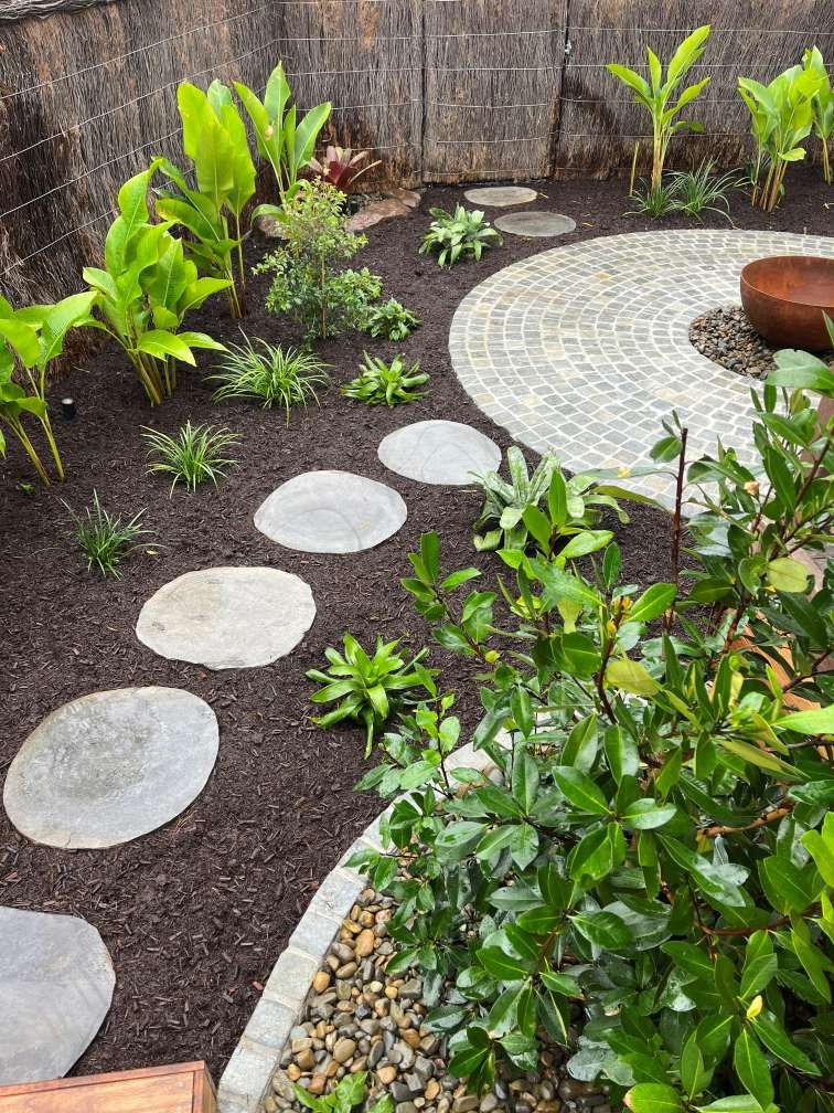A Garden With Stepping Stones and a Fire Pit in the Middle — Bloomscapes in Byron Bay NSW