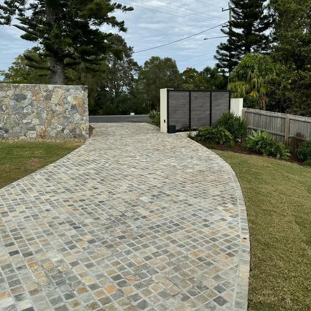 A Brick Driveway Leading to a House With Trees in the Background — Bloomscapes in Lennox Head NSW