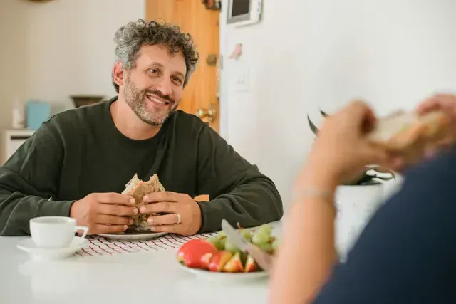 A smiling community member sharing a meal