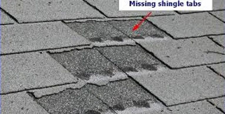 A close up of a roof with missing shingle tabs.