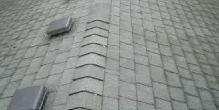 A close up of a roof with a lot of shingles on it.