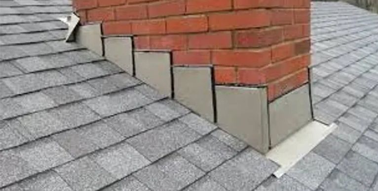 A brick chimney is sitting on top of a roof.