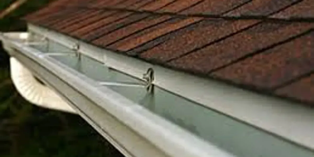 A close up of a gutter on a roof of a house.