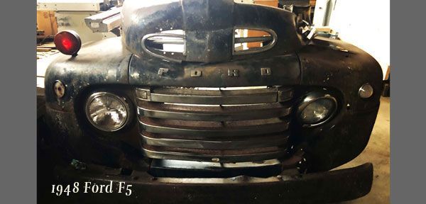 A 1948 ford f5 is parked in a garage