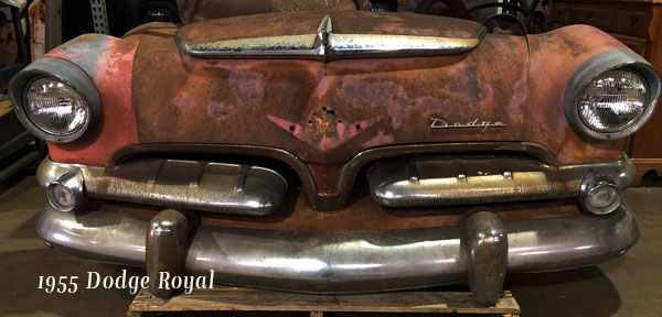 A rusty old dodge royal car is sitting on a wooden pallet.
