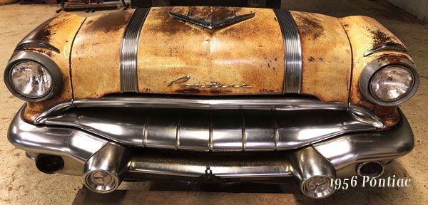 A 1956 pontiac is sitting in a garage.