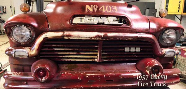 A red gmc fire truck is parked in a garage