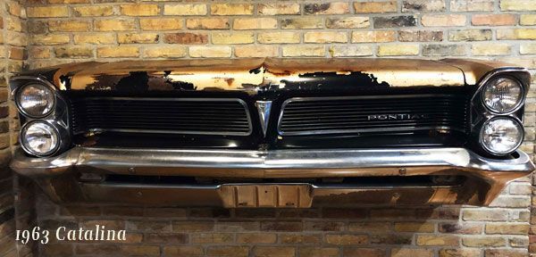 A 1963 pontiac catalina is hanging on a brick wall