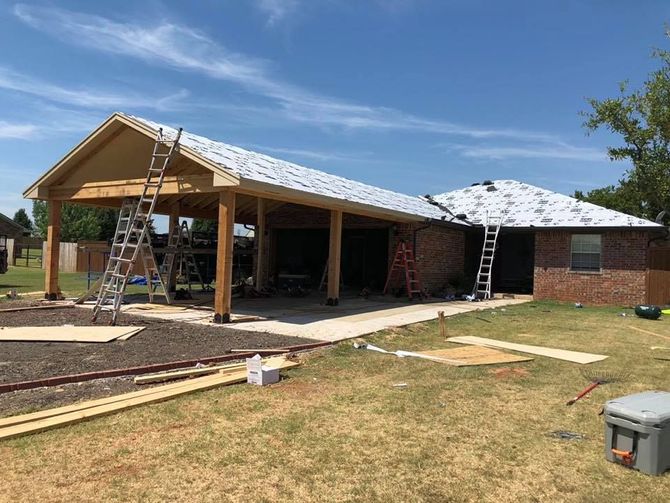 A house is being built with a roof that is being installed.