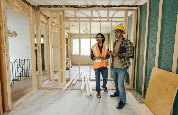 Two Construction Workers Are Standing In A Room Under Construction — Kingston, NY — T.I. Contracting Two Construction Workers Are Standing In A Room Under Construction — Kingston, NY — T.I. Contracting